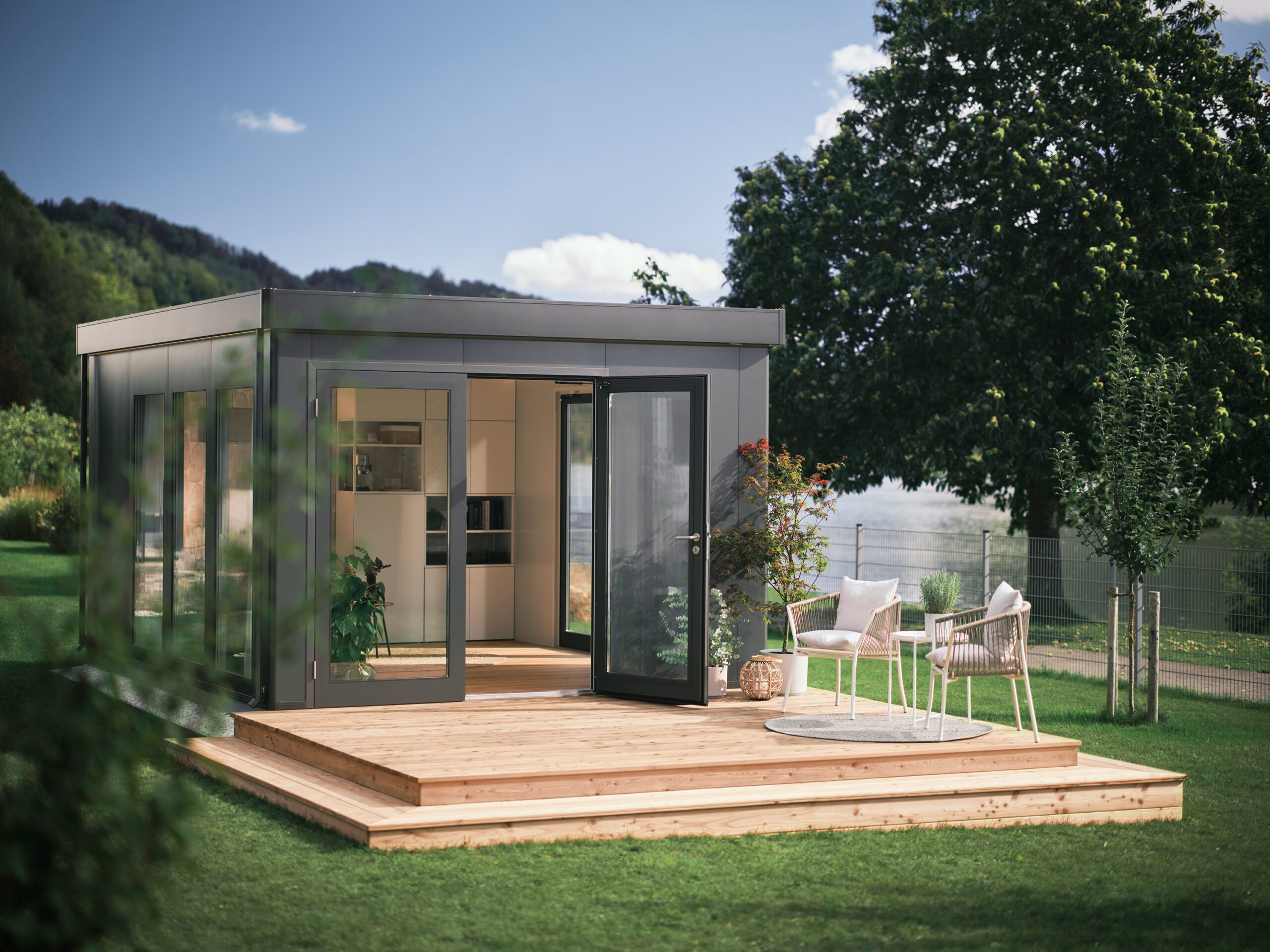 Dunkelgraues, modernes Gartenhaus und erweiterter Wohnraum mit Ganzglastüren, Fenstern und Flachdach in einem grossen Garten